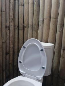 een wit toilet met deksel in de badkamer bij บ้านนอร์ดบล็อกเวนิสบ้านเวร in Ban Khun Nam Nan +21 foto's