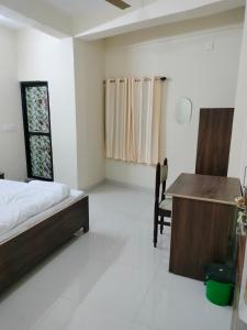 a bedroom with a bed and a desk and a chair at Hotel Krishn Residency in Garwa Road