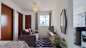 een woonkamer met een stoel en een spiegel bij Ótimo Custo-Benefício, Conforto e Praticidade in São Luís +27 foto's