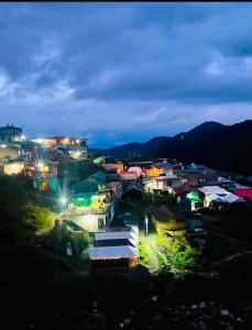 a town lit up at night with lights at Jaggi Guest House Chopta in Chopta +10 photos