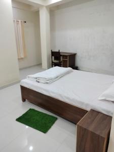 a bedroom with a bed with a desk and a green rug at Hotel Krishn Residency in Garwa Road +20 photos