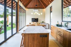 eine offene Küche mit einer großen Insel in einem Haus in der Unterkunft 2BDR Villa Aurelia - Construction nearby in Bedahulu