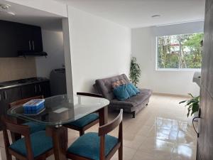 a living room with a glass table and a couch at Amplio apartamento 806 in Armenia