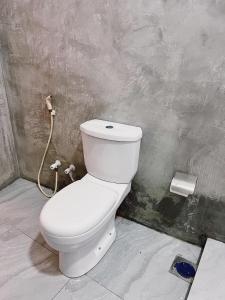 een badkamer met een wit toilet in een kamer bij Madu - Guesthouse & Local Restaurant in Weligama