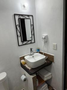 een badkamer met een wastafel en een spiegel aan de muur bij Del Cortes Cabañas in Velasco