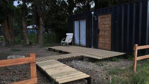 een stoel op een houten terras naast een hut bij Nomade Balmaceda in Coihaique
