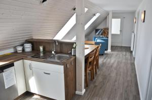 een keuken met een wastafel en een tafel in een kamer bij Schäferstübchen - Urlaub auf dem Bauernhof in Braunsberg