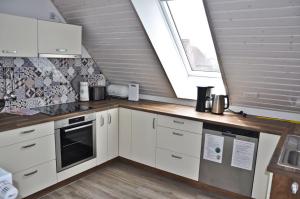 een keuken met witte kasten en een houten aanrechtblad bij Schäferstübchen - Urlaub auf dem Bauernhof in Braunsberg