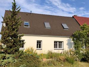 een wit huis met een bruin dak bij Schäferstübchen - Urlaub auf dem Bauernhof in Braunsberg +1 foto