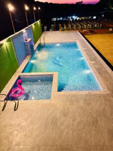 a swimming pool with a pink pair of scissors in it at ARANYAM By StarGlaze Retreat in Mahabaleshwar +42 photos