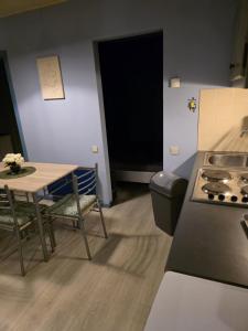 een keuken met een tafel, een tafel en een fornuis bij La Mésange Apprivoisée in Membre