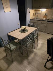 een houten tafel en stoelen in een keuken bij La Mésange Apprivoisée in Membre