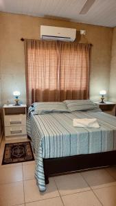 a bedroom with a bed and a window with a air conditioner at Casa Tekove in Clorinda