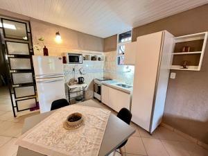 a small kitchen with a table and a white refrigerator at Casa Tekove in Clorinda