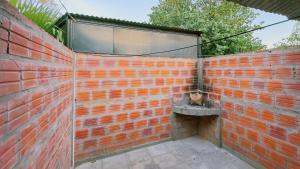 a brick wall with a cat sitting in a sink at Casa Tekove in Clorinda