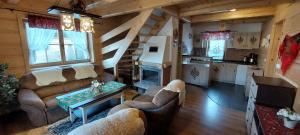 a living room with couches and a staircase in a cabin at Góralskie domki pod Koronami in Krościenko