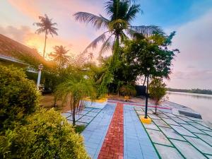 ein Resort-Pool mit Palmen und einem Gewässer in der Unterkunft CASA DE CANOLI - A Private backwater villa in Kodungallūr + 13 Fotos