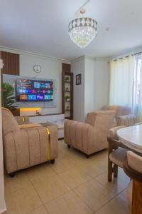 a living room with couches and a flat screen tv at SeyniKe 2BR Apartment - Nyali - AC, WiFi - Parking in Mombasa +15 photos