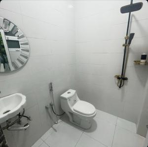 a white bathroom with a toilet and a sink at فندق وادي السحتن in Al Ambaḩ