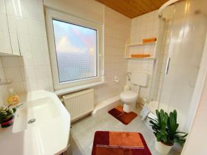 een badkamer met een wastafel en een toilet en een raam bij Ferienwohnung Landmannsruh in Lubmin +13 foto's