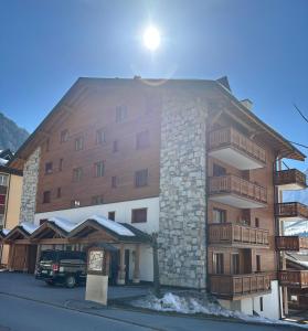 een groot appartementencomplex met sneeuw op de grond bij Residenz Darianne Leukerbad in Leukerbad