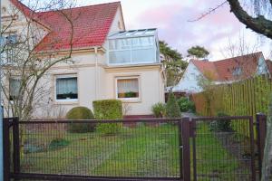 een wit huis met een rood dak bij Ferienwohnung Landmannsruh in Lubmin