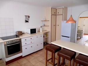 una cucina con frigorifero, tavolo e sedie di Fisherhaven Guest House a Hermanus