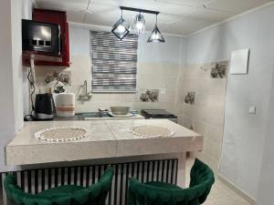 een keuken met een aanrecht en twee groene krukken bij Résidence Azur in Libreville