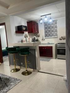 een keuken met een aanrecht en een paar groene barkrukken bij Résidence Azur in Libreville