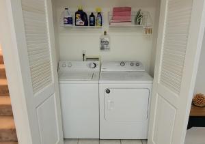 een witte wasruimte met een wasmachine en droger bij Mallard Cove - lakeside pet friendly in Robbinsville +13 foto's