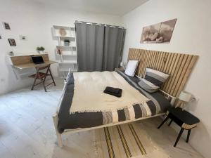 ein Schlafzimmer mit einem Bett und einem Schreibtisch mit einem Laptop in der Unterkunft Villa Margot in Fumel