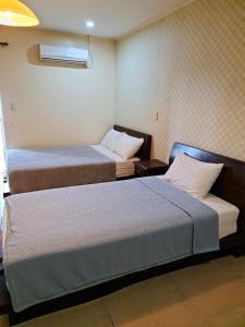 a hotel room with two beds and a window at Shine Hotel in Sampong