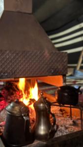 een vuurplaats met twee potten en pannen erin bij Diala luxury wadi rum in Wadi Rum