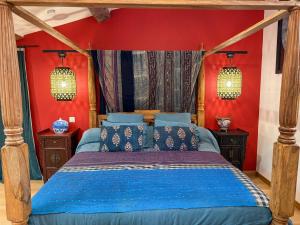 una camera con letto blu e pareti rosse di Origines a Tautavel