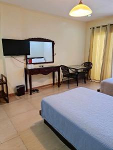 a bedroom with a desk and a table with a bed at Shine Hotel in Sampong