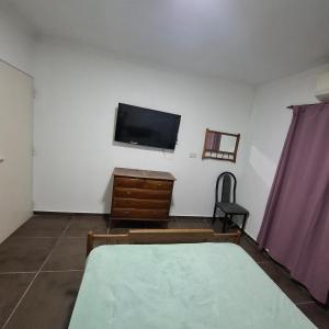 a bedroom with a tv and a dresser and a bed at very spacious house equipped for 4 people in Resistencia