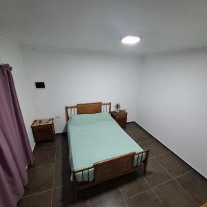 a bedroom with a bed and two night stands at very spacious house equipped for 4 people in Resistencia