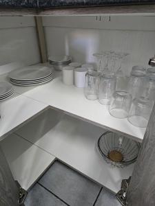 a kitchen with glasses and plates on a shelf at Lalapanzi - Nxabba in Olifantshoek