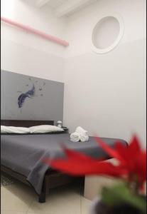 ein Schlafzimmer mit einem Bett und einer roten Blume in der Unterkunft KiMia Home, Near Airport & station in Modugno