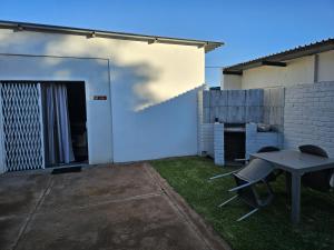 a patio with a table and chairs in a yard at Lalapanzi - Nxabba in Olifantshoek