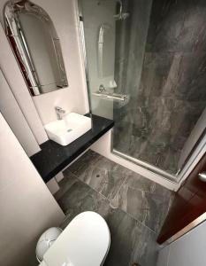 une salle de bains avec lavabo, toilettes et miroir dans l'établissement Hostal Llampayec, à Chiclayo