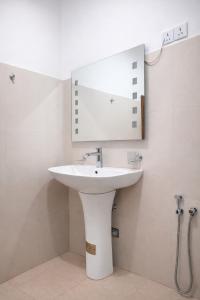 a bathroom with a white sink and a mirror at Amado Homestay Ella in Ella +68 photos