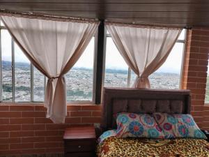 una camera da letto con letto e finestre con vista di Hospedaje Mágico Arcángel a Ibarra
