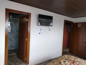 una camera con un letto e una televisione a parete di Hospedaje Mágico Arcángel a Ibarra