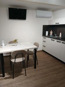 een keuken met een witte tafel en stoelen in een kamer bij Ubytování U Mecha 
