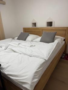 een groot bed met witte lakens en kussens bij Ubytování U Mecha 