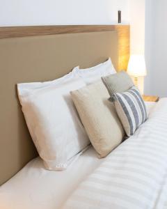 - une pile d'oreillers assises sur un lit dans l'établissement Hostal Llampayec, à Chiclayo