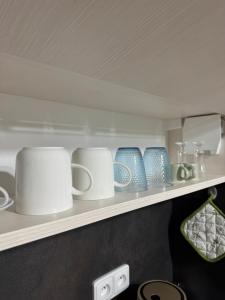 een plank vol witte en blauwe mokken bij Ubytování U Mecha 