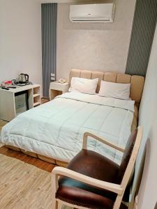 een slaapkamer met een groot bed en een stoel bij Pyrs Giza Heaven in Caïro