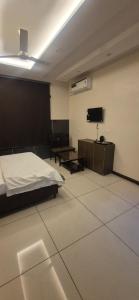 a bedroom with a bed and a flat screen tv at Hotel inn de dogras in Udhampur